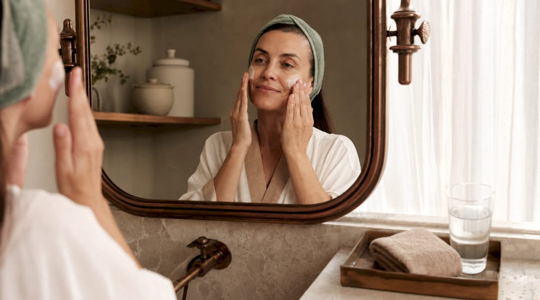 Woman applying Polish face cream at bathroom sink