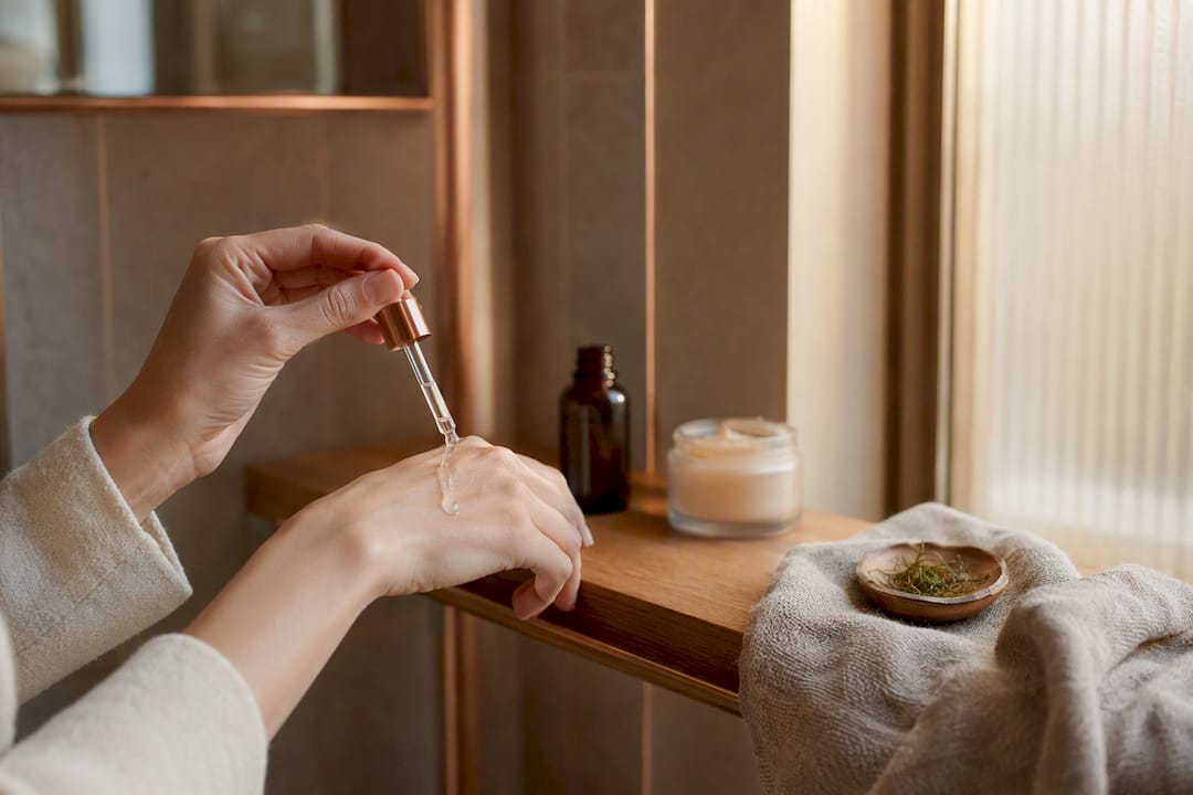 Hands applying retinol serum and collagen cream