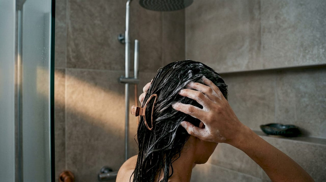 Hands massaging shampoo into wet hair